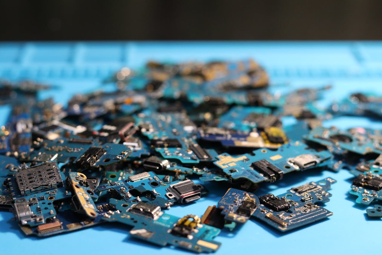 Pile of disassembled circuit boards on a blue surface. Perfect for tech themes.